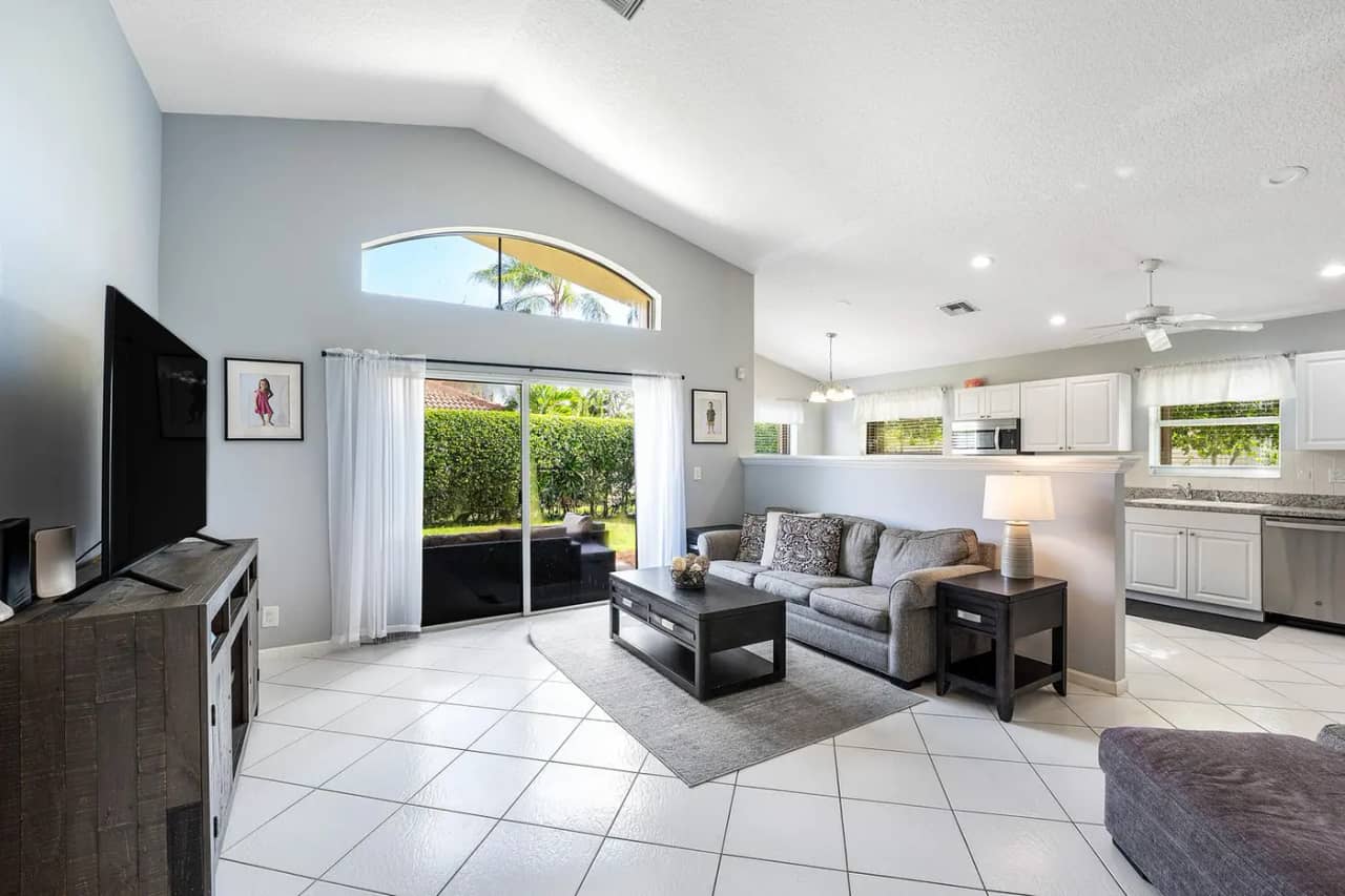Living room at 3907 Palladium View Drive with vaulted ceiling and sliding glass doors to the fenced backyard